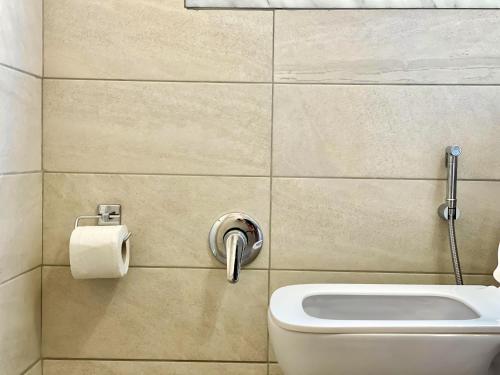 a bathroom with a toilet and a roll of toilet paper at Northgate Apart-Villa in Shkodër