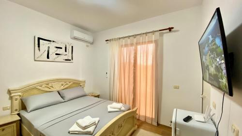 a bedroom with a bed and a flat screen tv at Northgate Apart-Villa in Shkodër