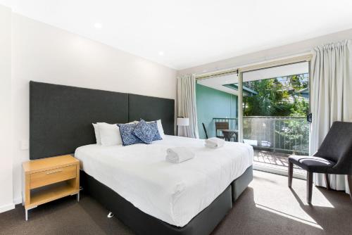 a bedroom with a large bed and a window at Cuttlefish Cove in Coffs Harbour
