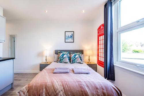 1 dormitorio con 1 cama con 2 almohadas y ventana en City studios london en Londres