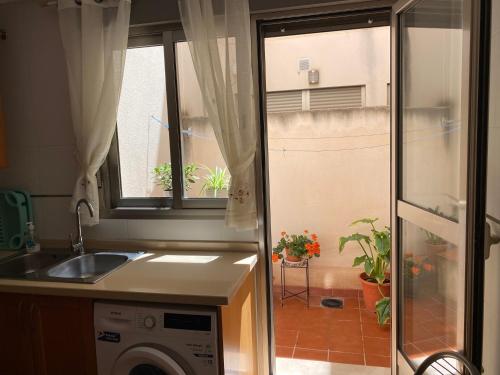 a kitchen with a sink and a washing machine at Apartamento San Vicente in Villar del Arzobispo