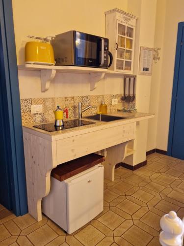 een keuken met een wastafel en een magnetron bij Cla&Cha Studio in Bonassola