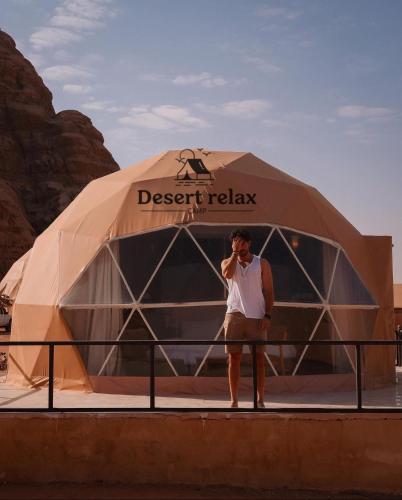 Ein Mann, der auf einem Handy vor einem Zelt spricht in der Unterkunft Desert relax camp in Wadi Rum