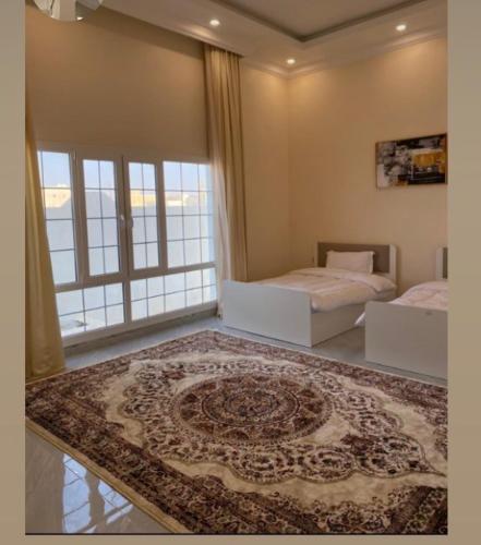 a bedroom with two beds and a rug on the floor at Alrabe3 شاليه 