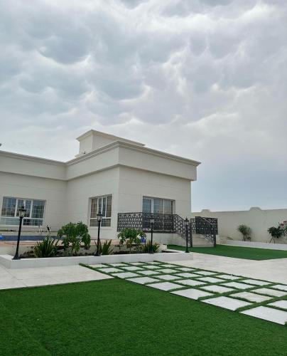 a building with a green lawn in front of it at Alrabe3 شاليه 