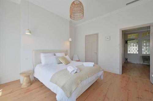 une chambre blanche avec un lit avec des serviettes dessus dans l'établissement Une Nuit d'été - Vue Palais des Papes - Clim - Wi-Fi - Double terrasse - Parking gratuit, à Avignon