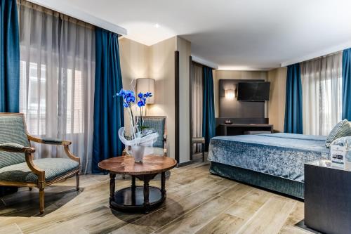 Habitación de hotel con cama, mesa y silla en Hotel Reina Cristina en Teruel