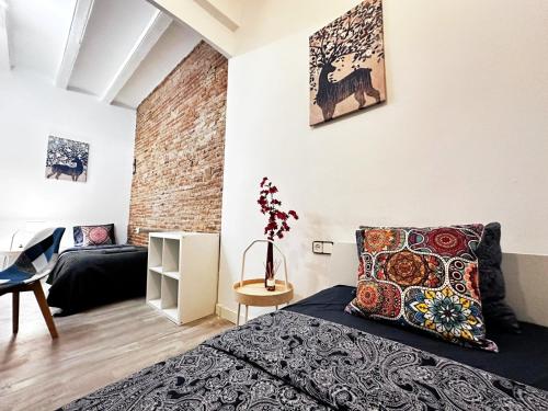 1 dormitorio con cama y pared de ladrillo en Near La Rambla Rooms, en Barcelona