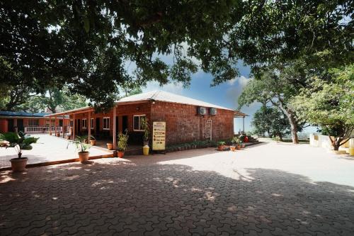 a brick building with a brick driveway in front of it at Dwarka Lawns Cottages in Mahabaleshwar