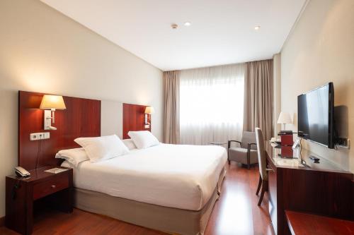 a hotel room with a bed and a flat screen tv at Hotel Attica21 Las Rozas in Las Rozas de Madrid