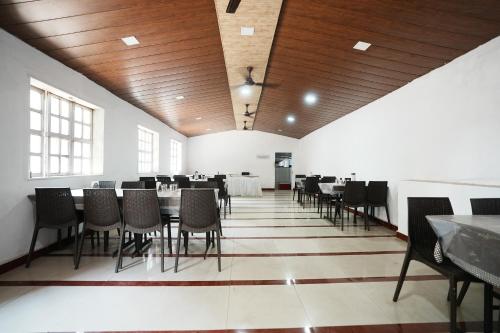 Un comedor con mesas y sillas en un edificio. en Dwarka Lawns Cottages, en Mahabaleshwar