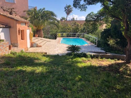 une piscine dans une cour à côté d'une maison dans l'établissement Charmant Appartement, à Fréjus