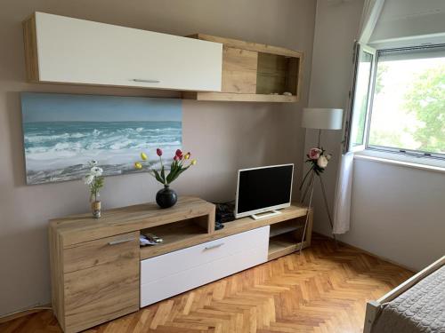 a living room with a tv and a desk with a computer at Apartment 877-1 in Bibinje