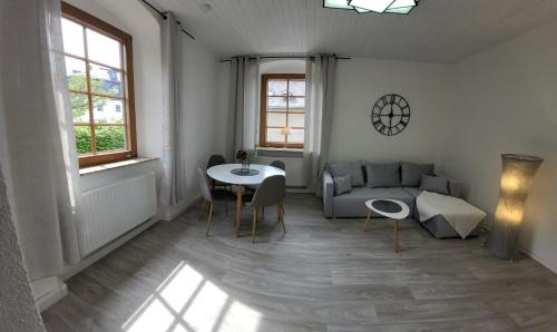 een woonkamer met een bank en een tafel bij Ferienwohnung Frauenmarkt in Schneeberg