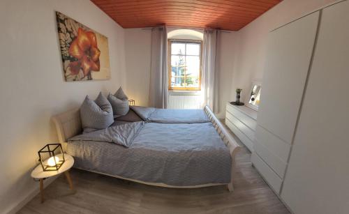 een kleine slaapkamer met een bed en een raam bij Ferienwohnung Frauenmarkt in Schneeberg