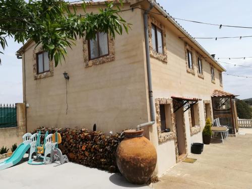 a house with a large vase next to a playground at Villa rural de campo aldea Las Zorizas in Munera