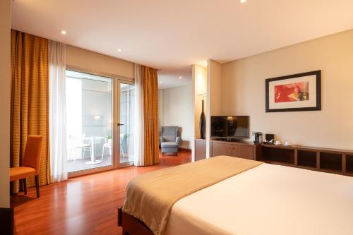 a hotel room with a bed and a balcony at Hotel Attica21 Las Rozas in Las Rozas de Madrid