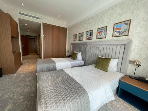 a hotel room with two beds and a television at Arena Grand Hotel in Quba