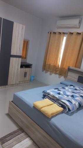 a bedroom with a bed with two towels on it at CG BNB HOTEL in Chiang Mai