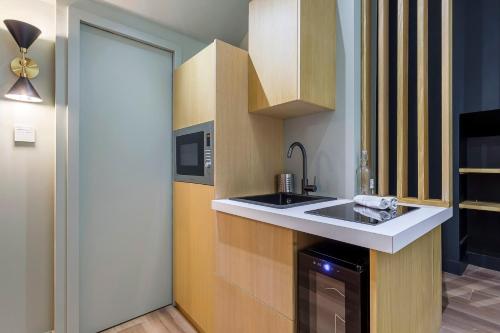 une cuisine avec un évier et un micro-ondes dans l'établissement Suite Romantique Balnéo Centre Lyon, à Lyon