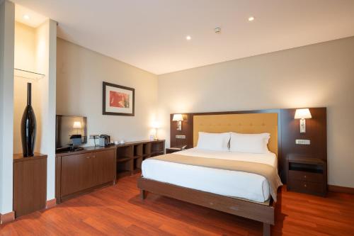 a hotel room with a bed and a television at Gran Hotel Attica21 Las Rozas in Las Rozas de Madrid