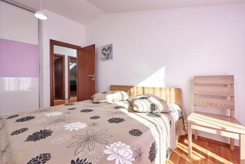 1 dormitorio con cama y silla de madera en Apartment in Trogir with terrace, air conditioning, WiFi, washing machine 4215-1, en Trogir