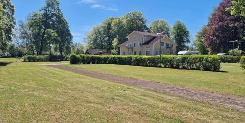 a house with a large yard with a driveway at Charlottsborgs Camping och Vandrarhem in Kristianstad