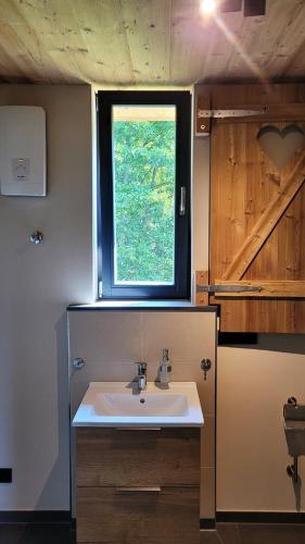 a bathroom with a sink and a window at Baumhaushotel Solling in Uslar