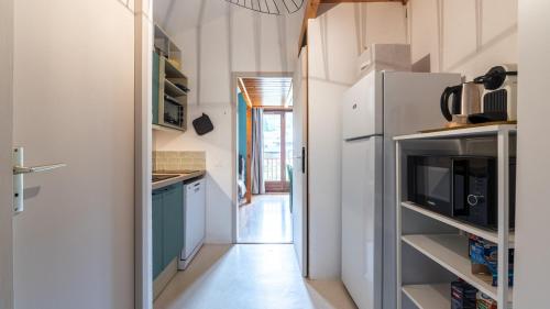 La cuisine est équipée de placards bleus et d'un réfrigérateur. dans l'établissement LES ARCADES - 310 - Appt accueillant 4-6 pers, à Morillon