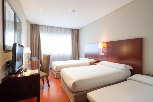 a hotel room with two beds and a television at Hotel Attica21 Las Rozas in Las Rozas de Madrid