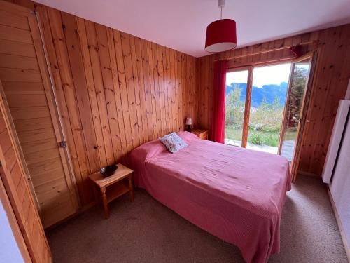 ein Schlafzimmer mit einem rosa Bett und einem Fenster in der Unterkunft Chalet rose des vents in Crans-Montana