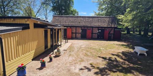 a small house with a yard next to a building at Charlottsborgs Camping och Vandrarhem in Kristianstad
