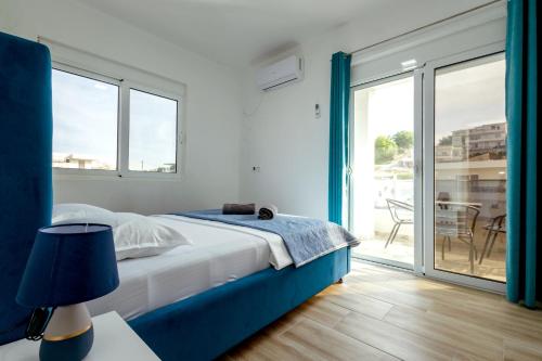 a bedroom with a bed and a sliding glass door at DERON Apartments in Ulcinj