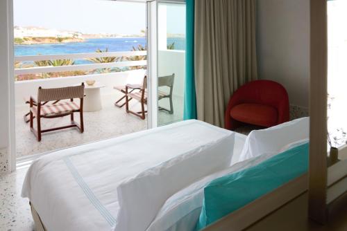 a bedroom with a bed and a view of the ocean at Nammos Hotel Mykonos in Psarou
