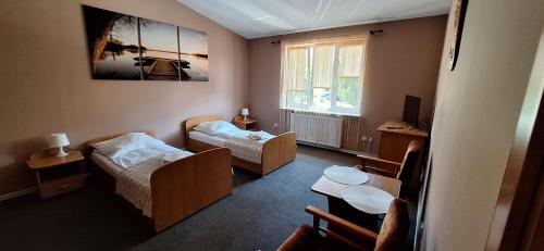 a small room with two beds and a table at Hotel Grodzki in Sandomierz