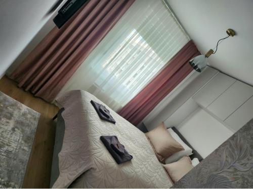 Ce lit se trouve dans une petite chambre dotée d'une fenêtre. dans l'établissement Apartman MK, à Lukavica