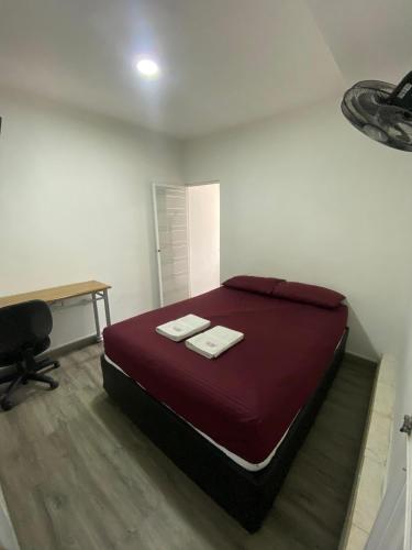 een slaapkamer met een bed met twee handdoeken erop bij Apartamento in Cartagena