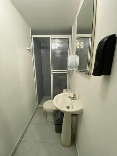 een badkamer met een toilet, een wastafel en een spiegel bij Apartamento in Cartagena