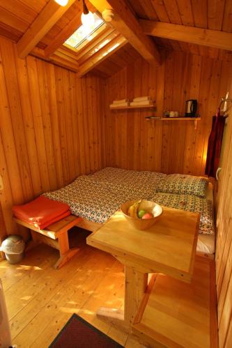 a room with a bed and a bowl of fruit on a table at Baumhaushotel Solling in Uslar