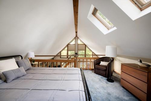 una camera da letto con un letto e una sedia in mansarda di Chalet w Hot Tub, Grill, FirePit, WiFi,PetFriendly a Morton Grove