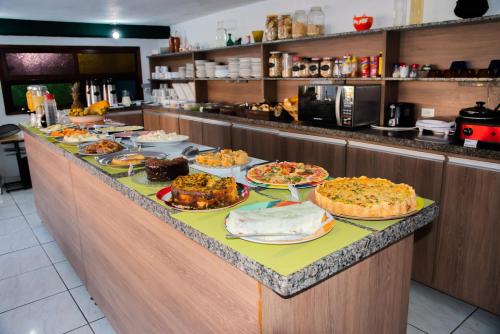 ein Buffet mit vielen verschiedenen Speisen in der Unterkunft Hotel Halloween Inn Penedo in Penedo