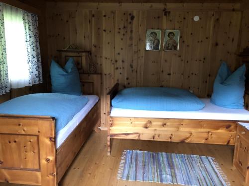 2 camas en una habitación con paredes de madera en Lanzer Obheimat, en Außervillgraten