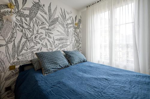 - une chambre avec un lit bleu et un papier peint floral dans l'établissement Studio design tout équipé avec balcon, à Paris