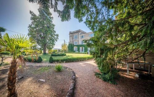 un jardin en face d'une grande maison dans l'établissement Château du Serpolet, à Pont-du-Château