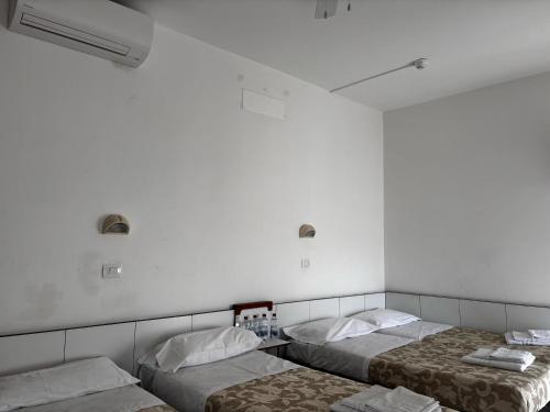 twee bedden in een kamer met witte muren bij HOTEL NOVECENTO in Cattolica