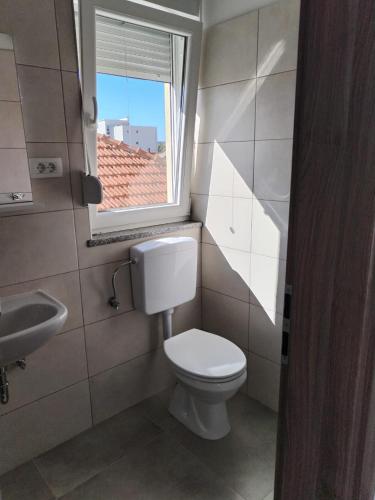 a small bathroom with a toilet and a window at Adriatica in Zadar