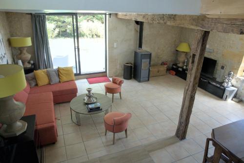 - un salon avec un canapé rouge et une cheminée dans l'établissement La Parenthèse Girondine, à Pujols Gironde