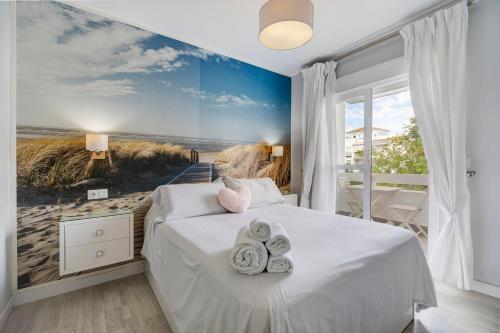 a bedroom with a bed with towels on it at Casa Blanca in Rota