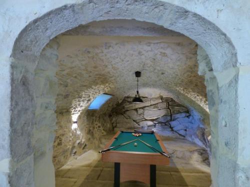 a cave with a pool table in a stone tunnel at Camin'hôtes Gîte Spa Drôme Lavande in Béconne