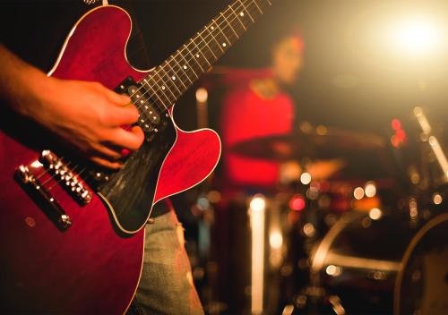 a person playing a red guitar on a stage at Viking Line - Overnight Cruise from Stockholm in Stockholm